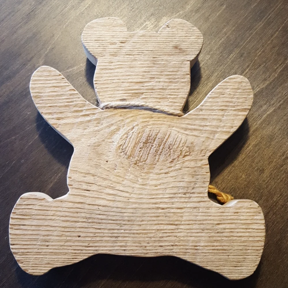 Wooden teddy bear cutout with copper heart.